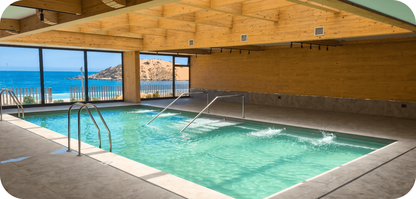 Piscina interior temperada con vista al mar